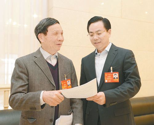 黃伯云代表（左）與劉國忠代表商討完善《關于建立戰略性新興產業國家創新平臺》的建議。 本報記者 張目 攝